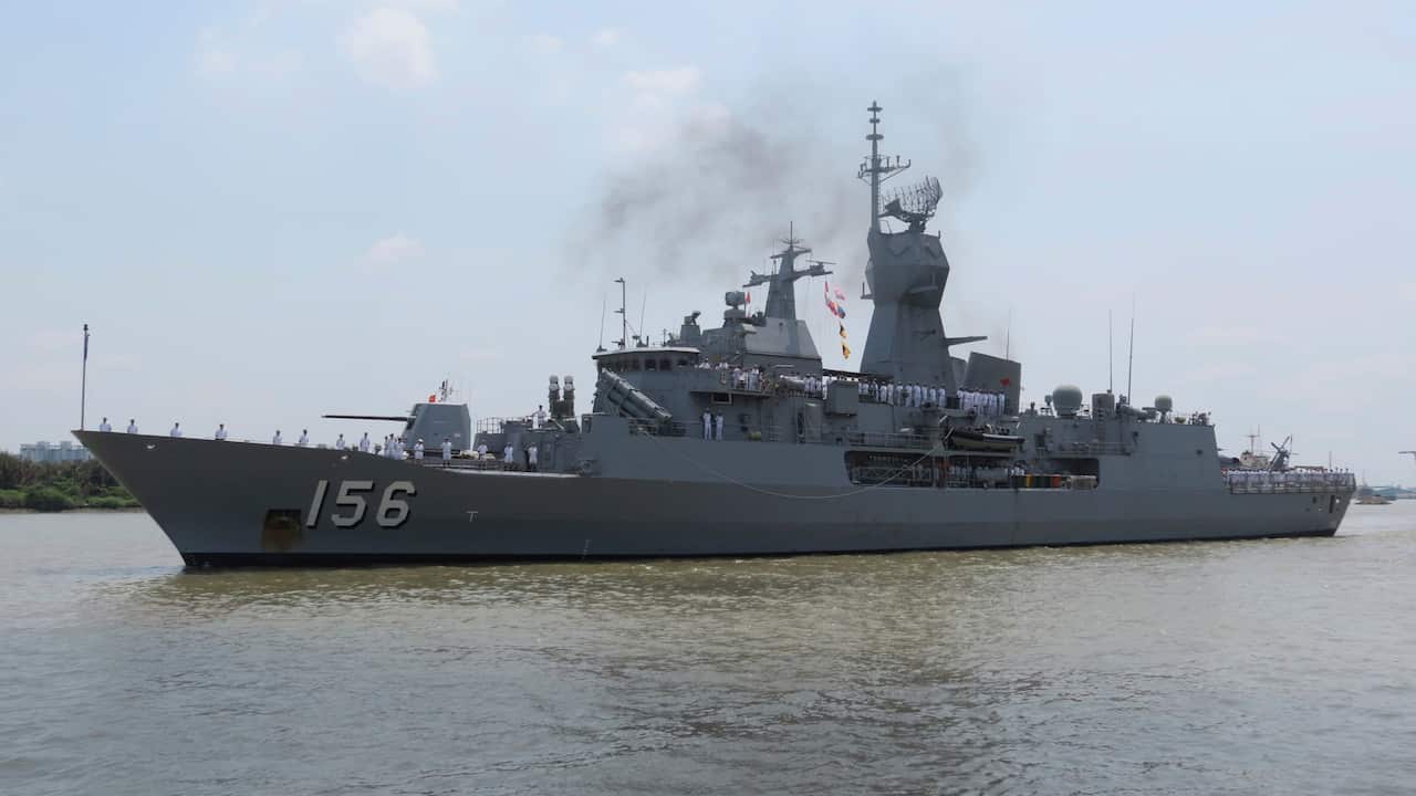 A large navy ship on the water
