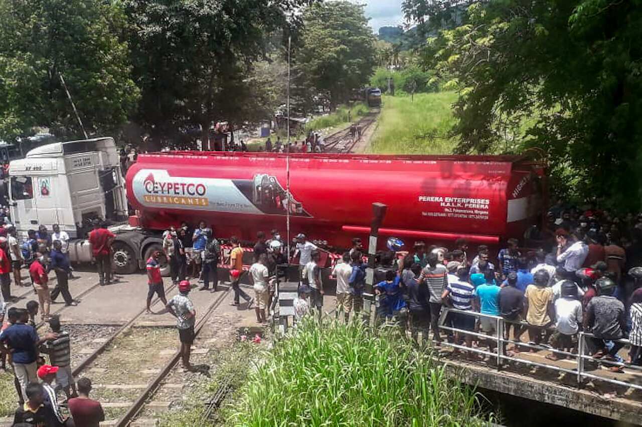 Protesters surround a truck that across a railway line.