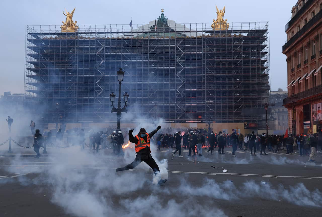 A protester kicks a tear gas canister.