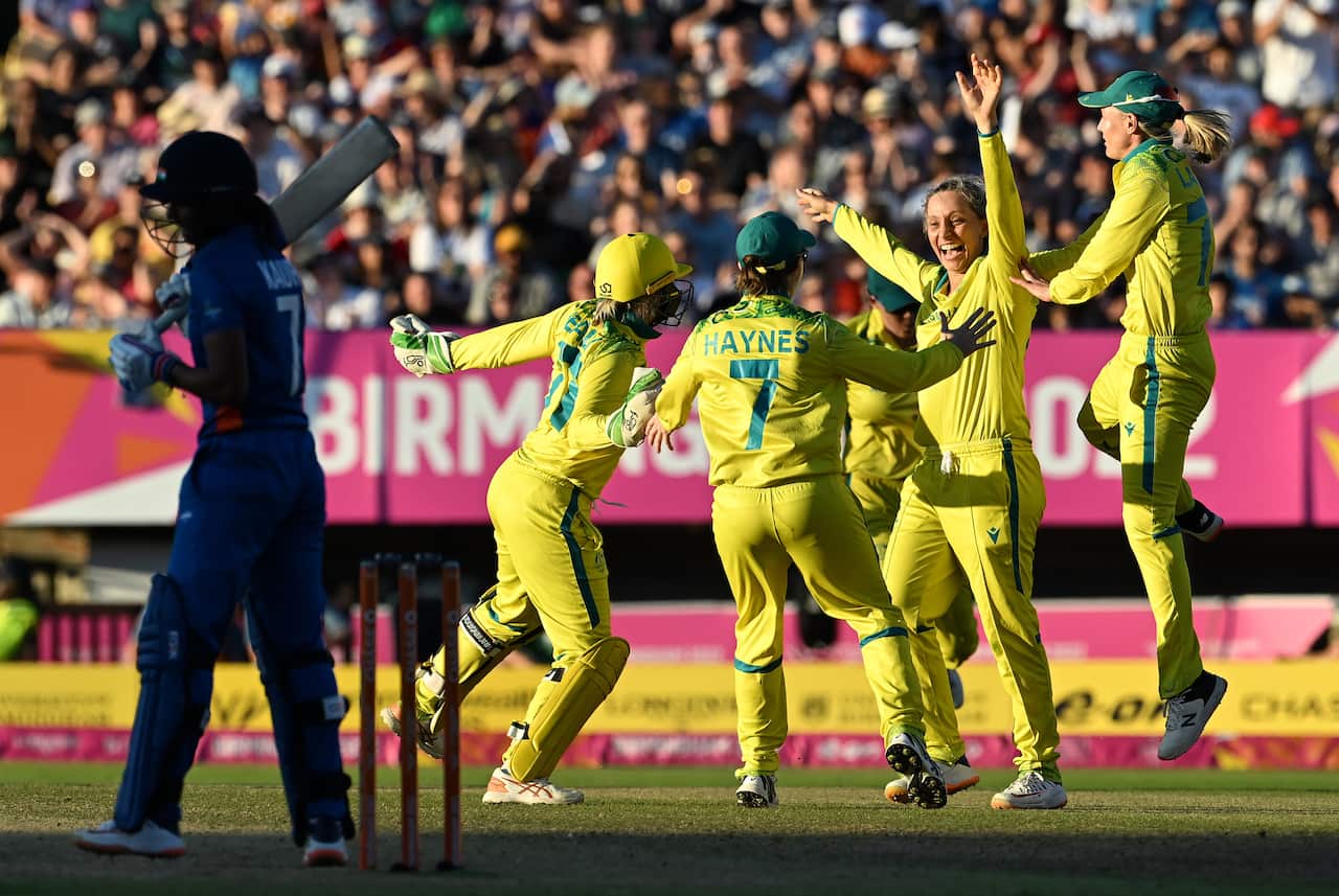 Cricket players cheer while on the field.