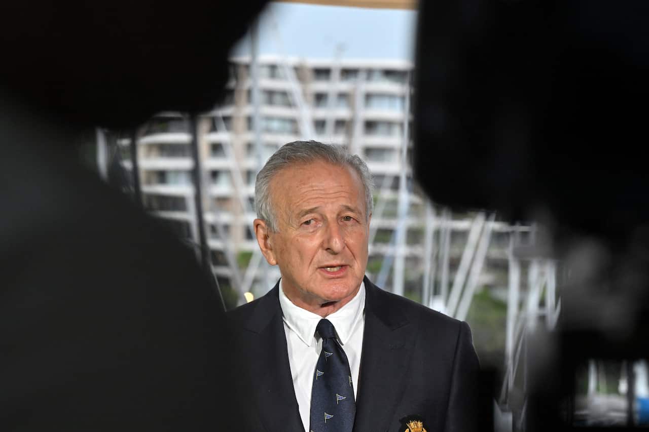 A man in a suit and tie speaks at a press conference