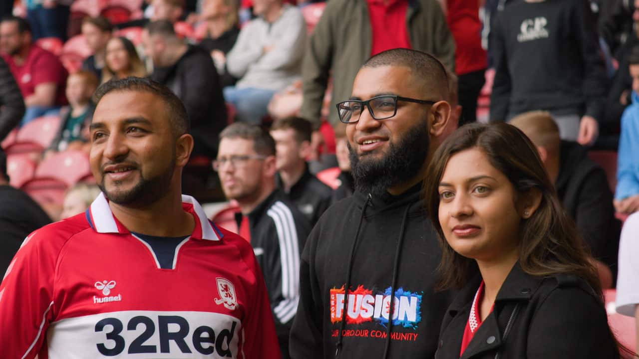 Three people watching a football game.