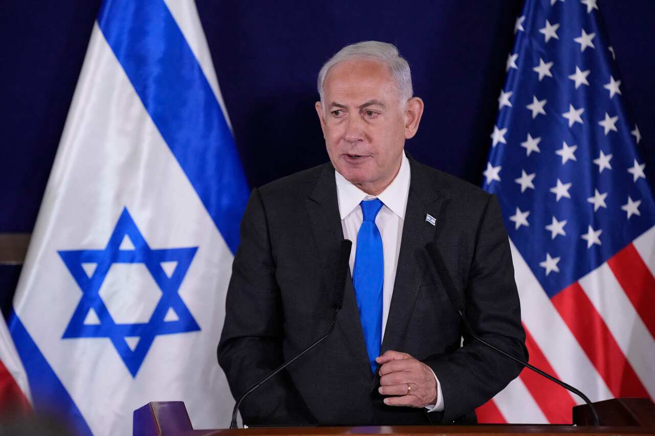 Israeli Prime Minister Benjamin Netanyahu speaks at a lectern in front of the Israeli and US flags. 