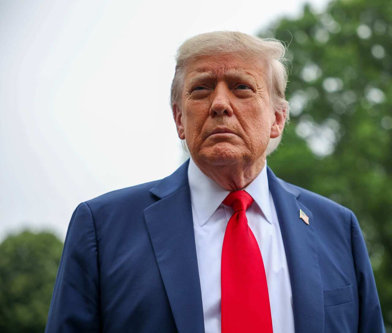 Donald Trump standing looking serious