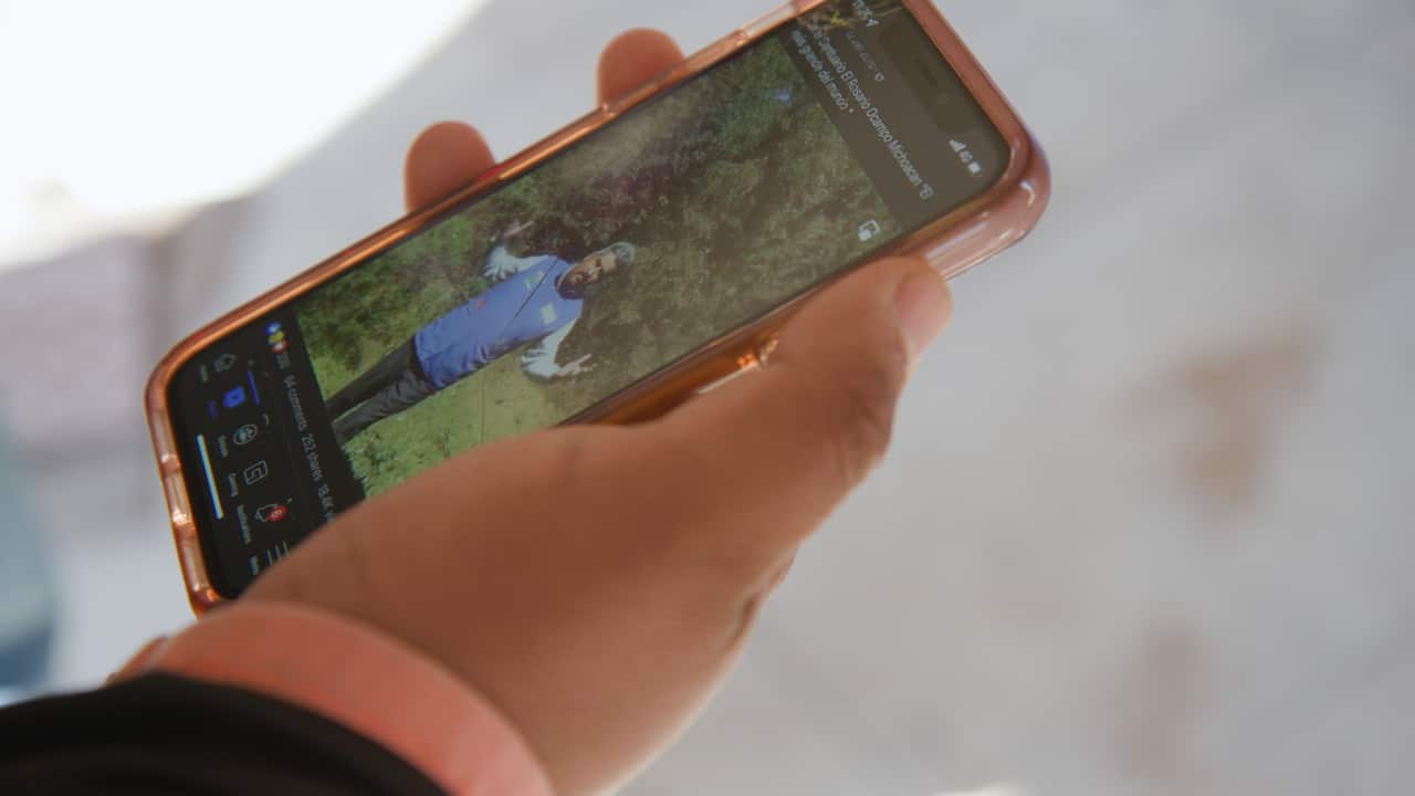 Homero Gomez Valencia holds a mobile phone which plays a video of his father Homero Gomez Gonzalez, that he filmed in the El Rosario Butterfly Sanctuary in 2020. 