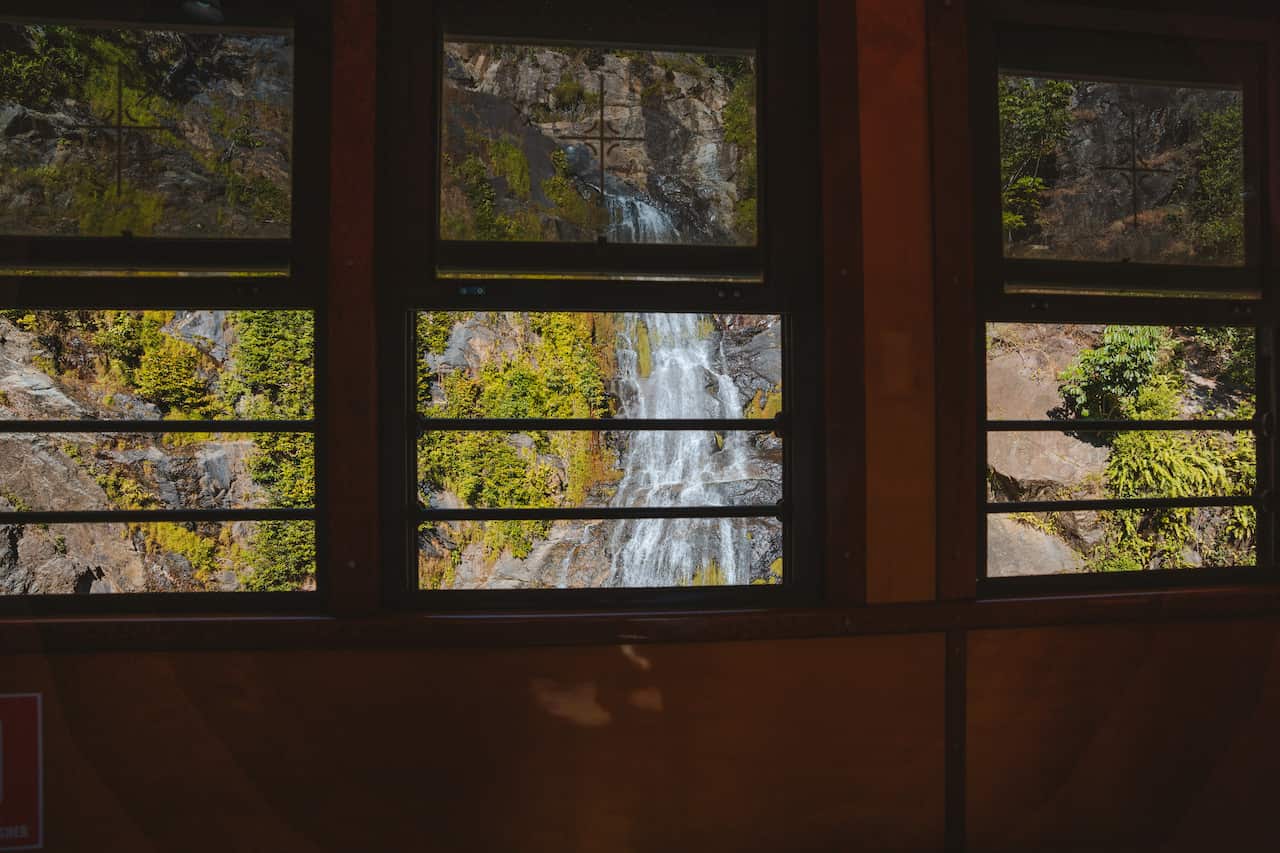 A view of a waterfall out of a train window.