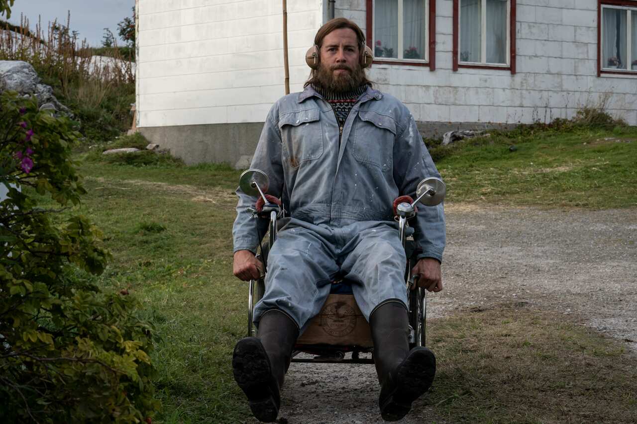 A sits in a wheelchair with motorcycle side mirrors