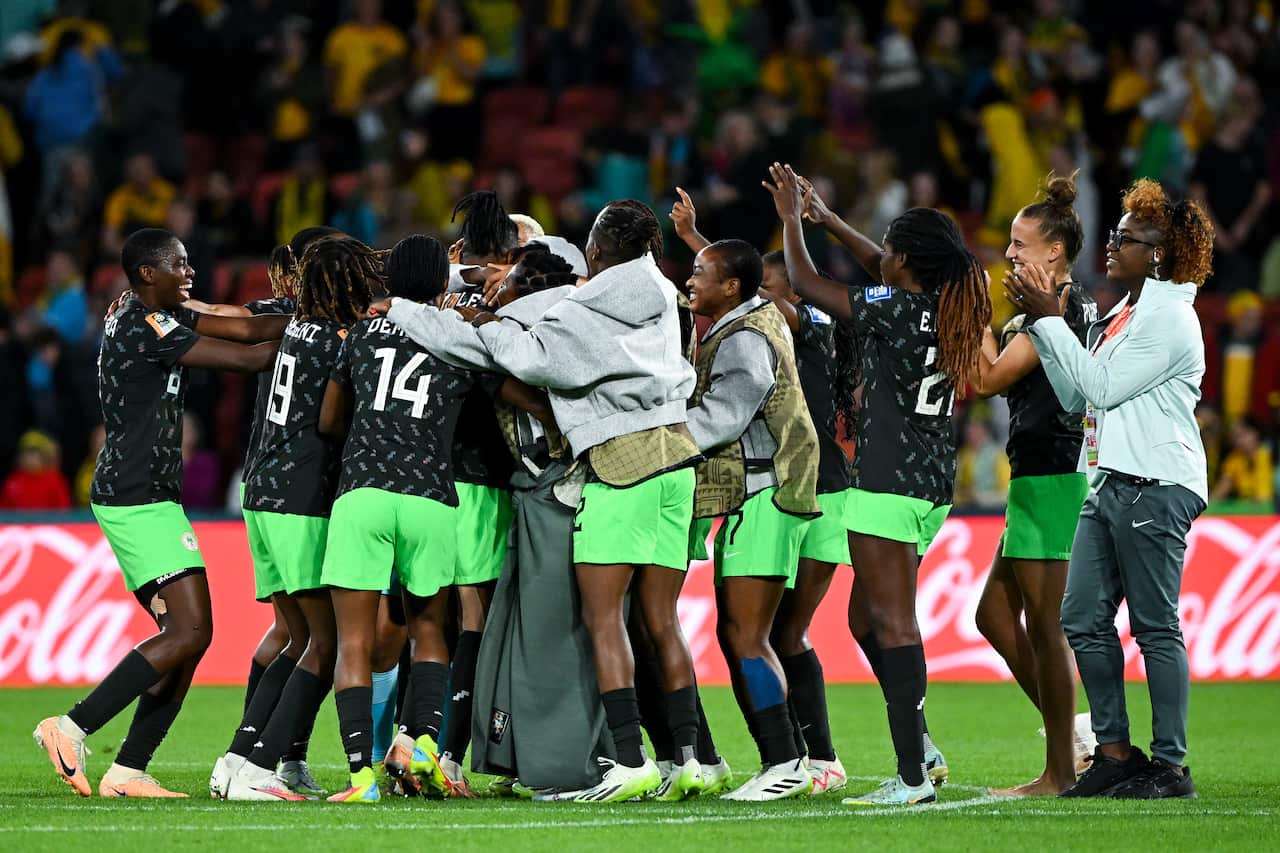 A large group of football players and crew celebrating.