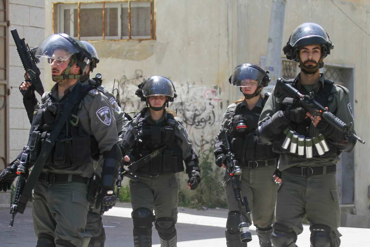 Israeli army soldiers holding guns and in protective clothing.