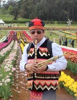 Dr Txawj pov hnav tsoos Hmoob yeeb duab ntawm ib thaj paj tulip (Dr Pao Saykao).jpg