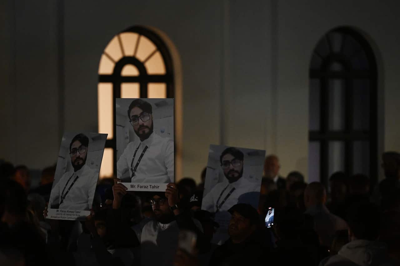 People hold up signs at a vigil