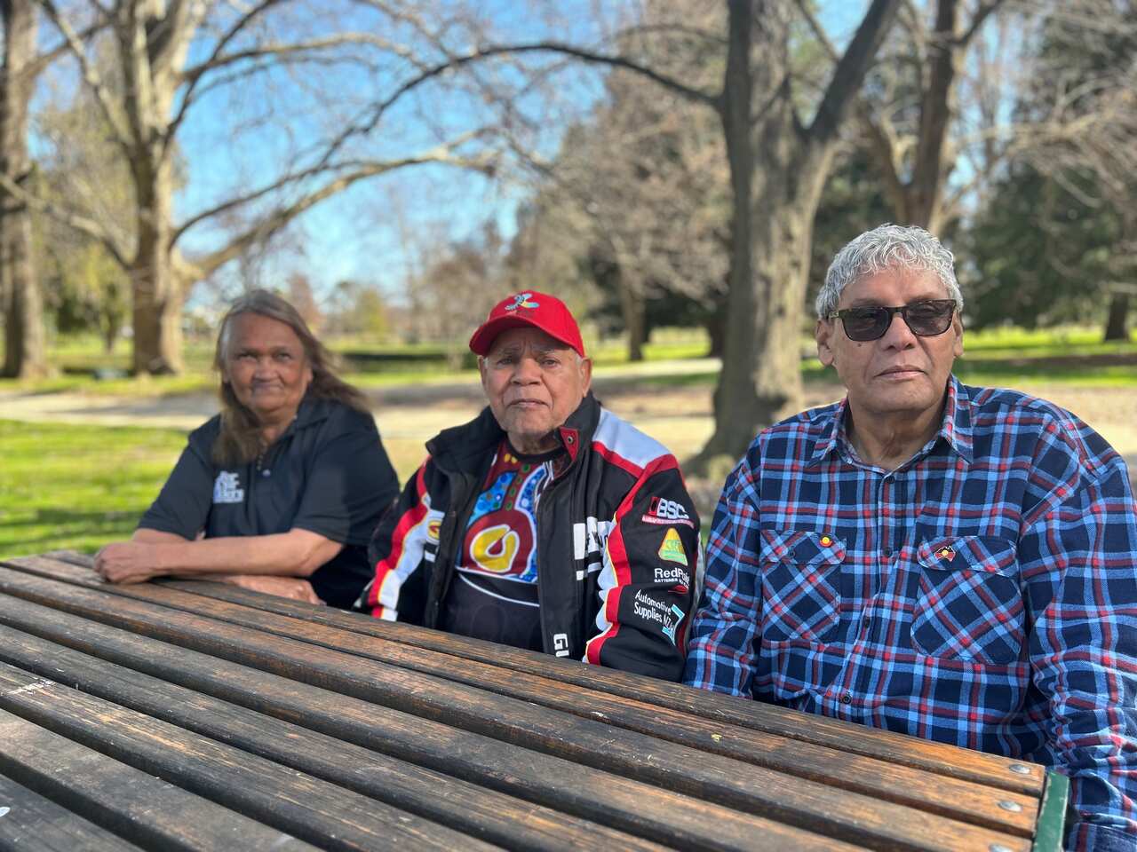 Aunty Alice Williams, Uncle Vic and Uncle Neil Ingram sitting at a wooden table in a park in Orange.