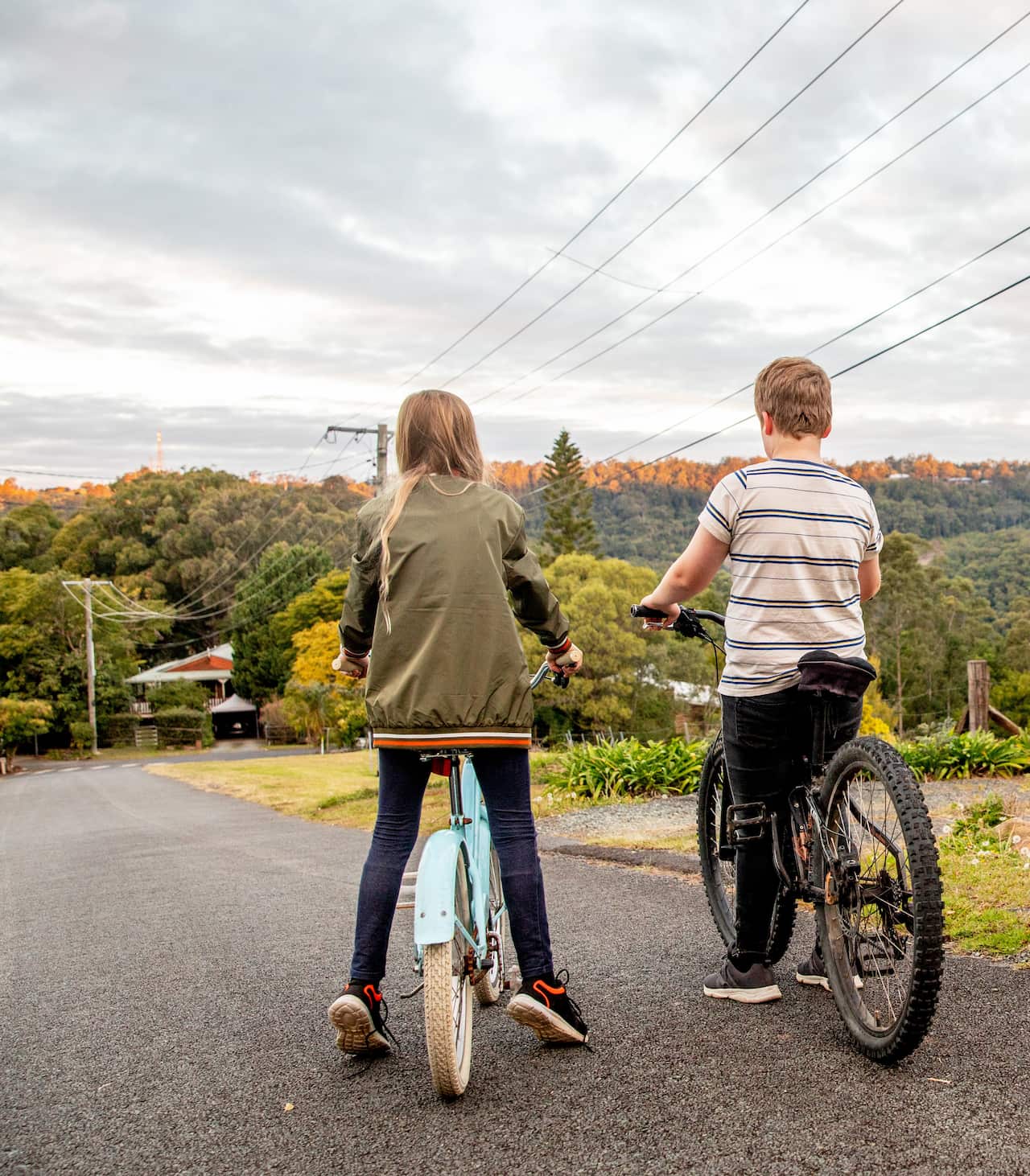 Two children on bikes, pictured from behind.