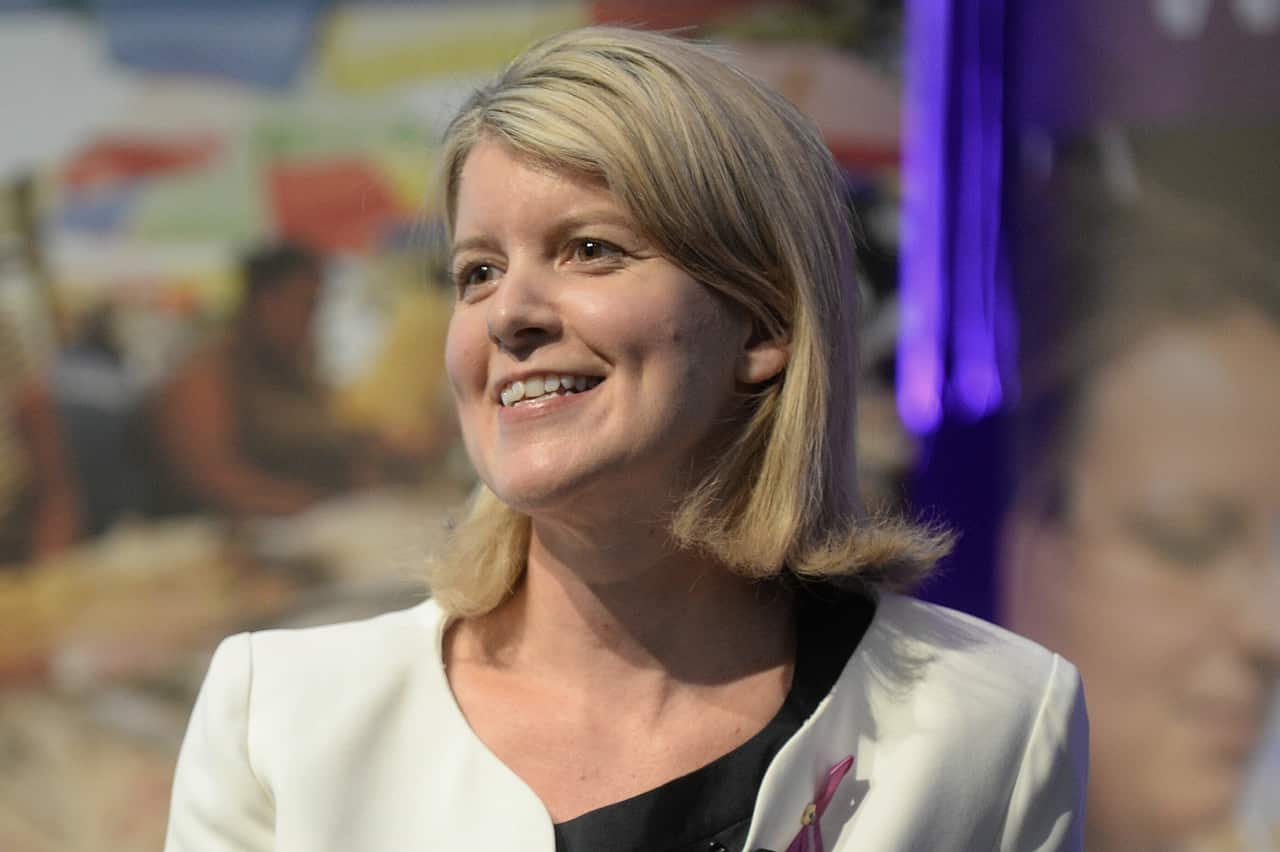 A blonde woman staring left at the camera.