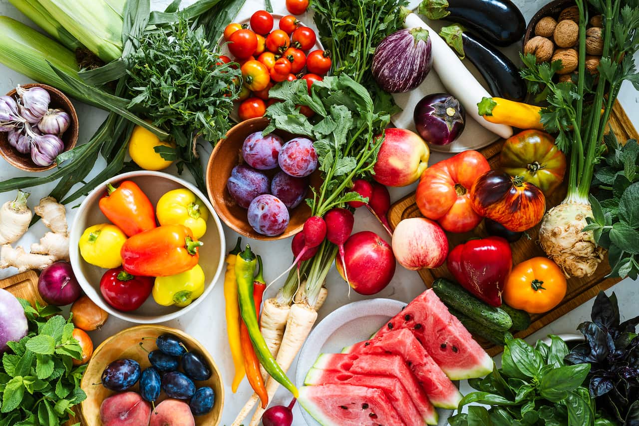 Fresh homegrown vegetables and fruits on kitchen table, summer harvest still life, table top view