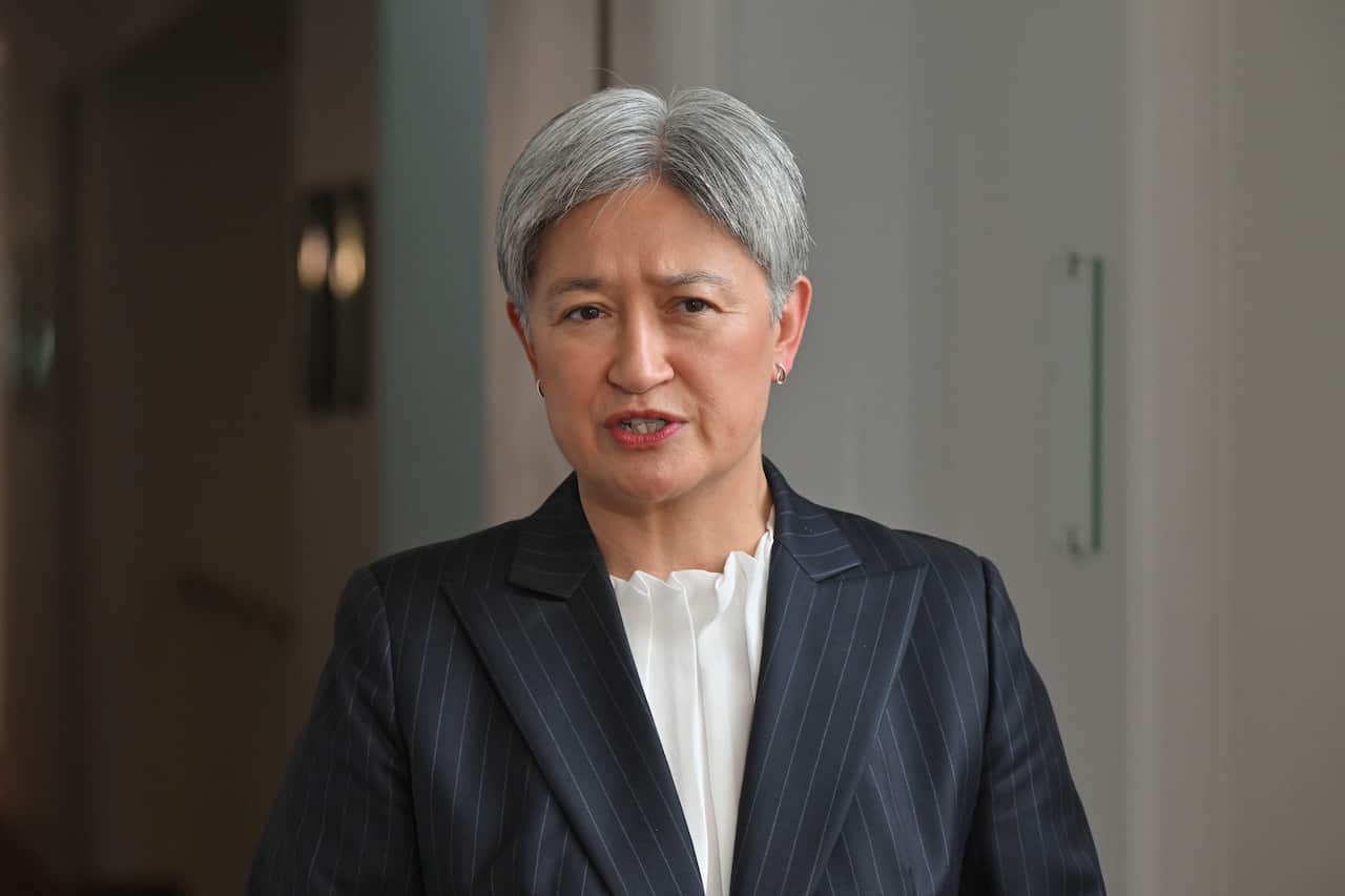 Penny Wong at a press conference wearing a suit.