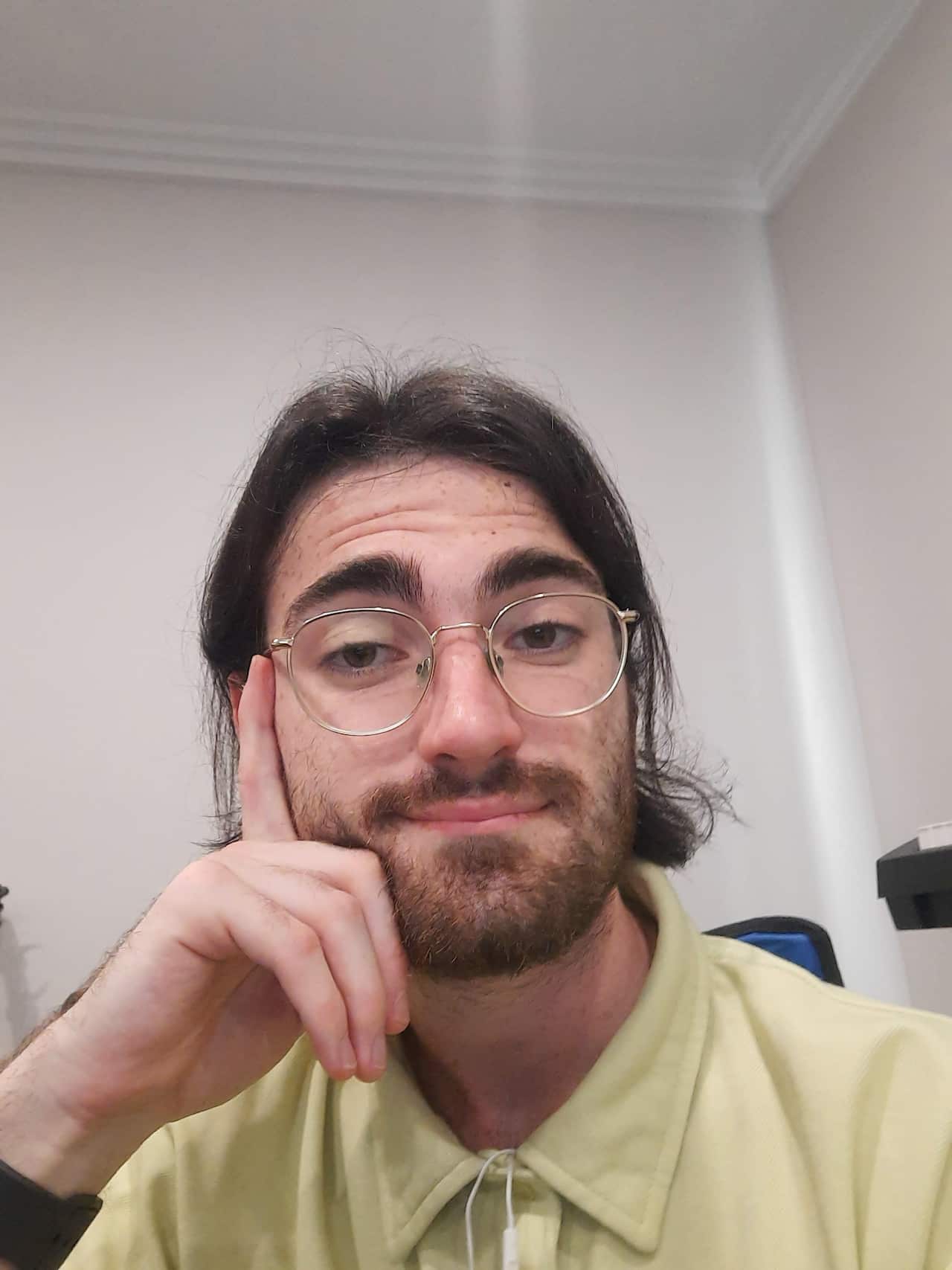 A man in glasses and a yellow polo shirt