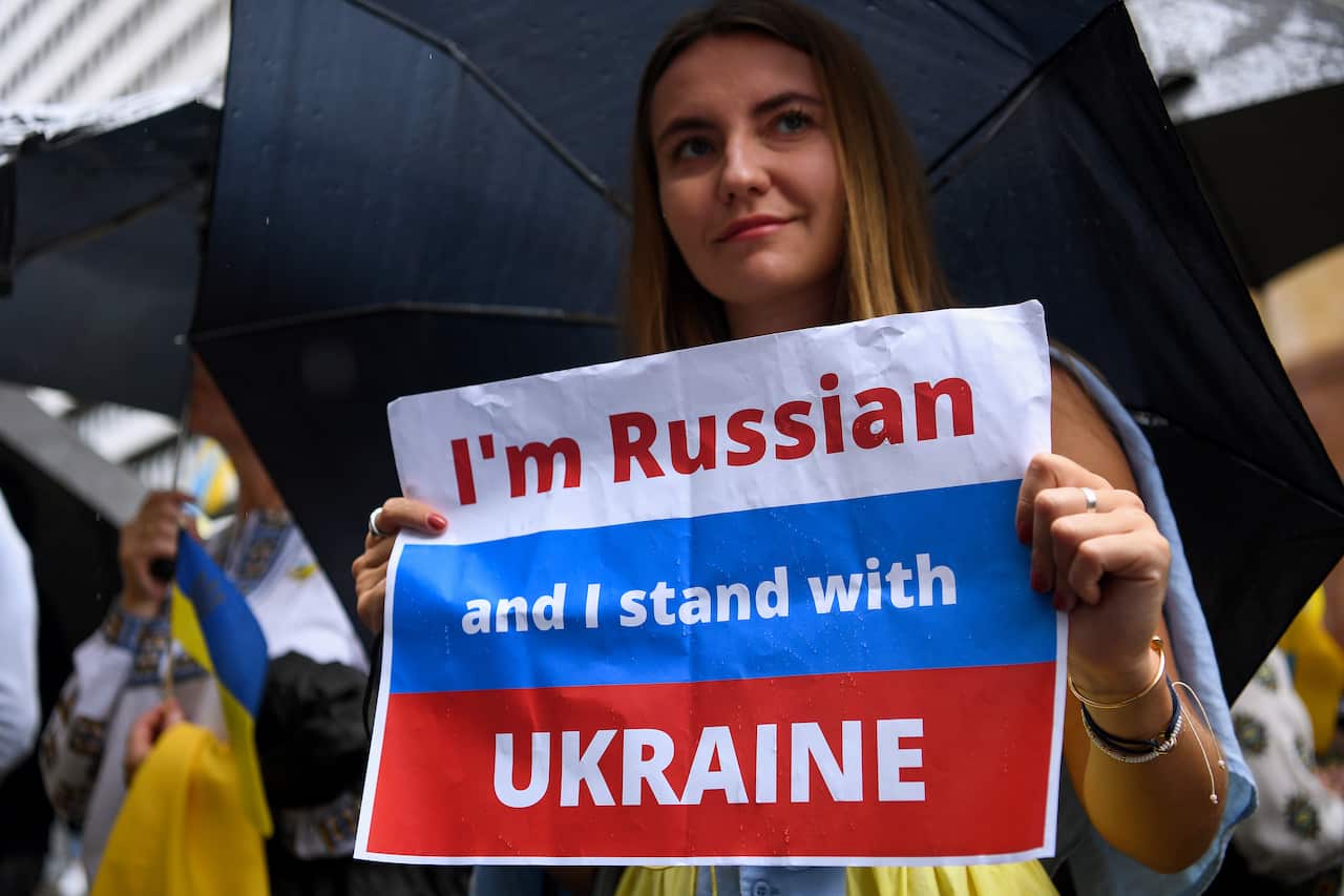 A woman holds a sign which reads "I'm Russian and I stand with Ukraine" at Martin Place in Sydney. 