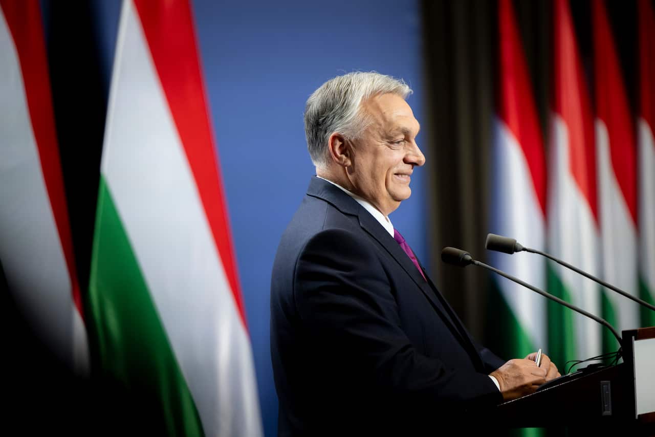 A man in a suit speaking into a lectern 