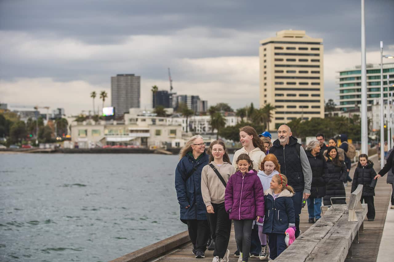People standing in a queue at a pier.