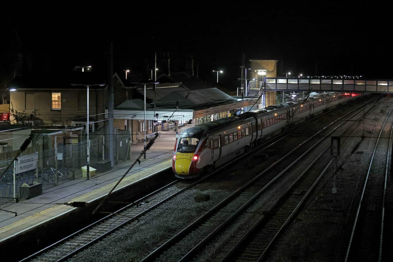 An aerial view of a train alongside a platform at night