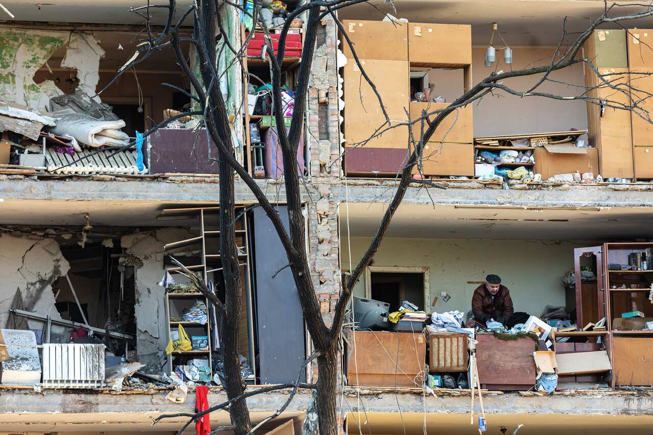 A resident collecting his belongings in a destroyed apartment building in Kyiv's Podilskyi district.