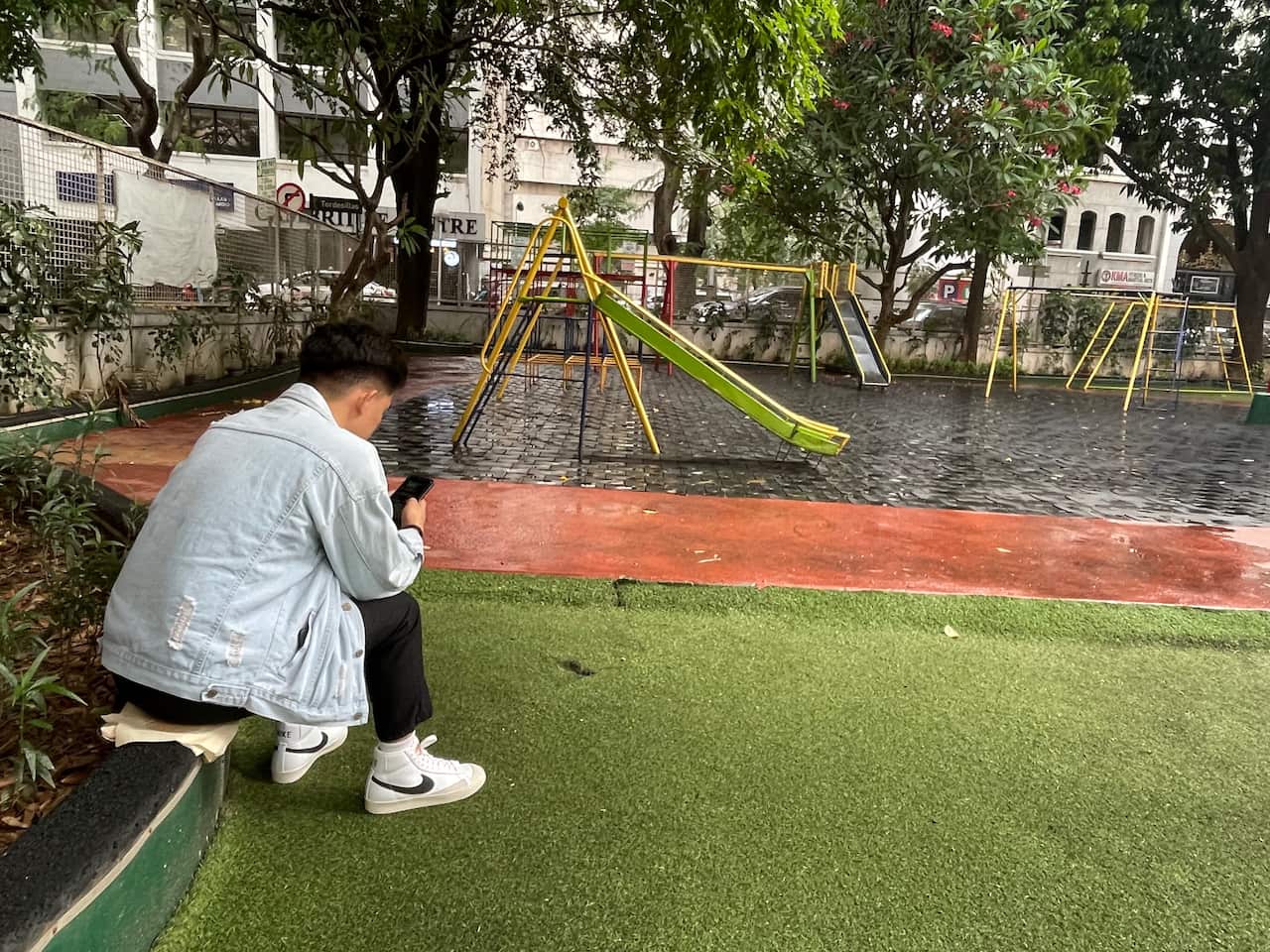 Young man sitting in playground