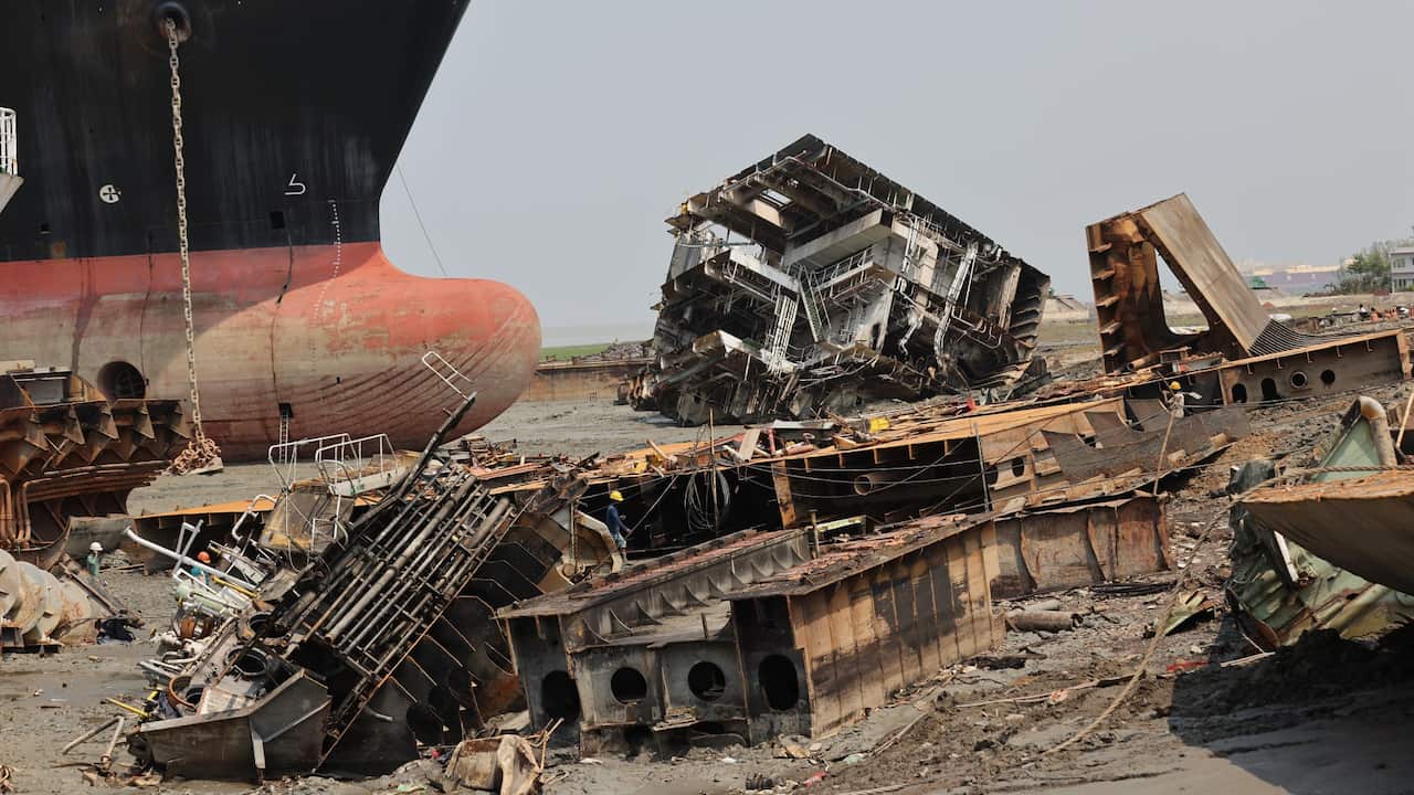 Broken rusty carcasses of old cargo ships beached in the mud