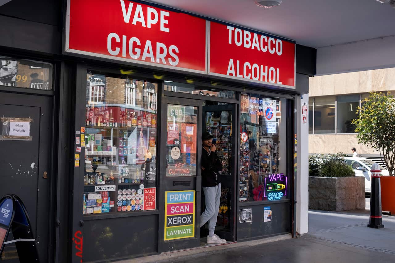 A corner shop in London, England, advertising vapes and tobacco on its front. 