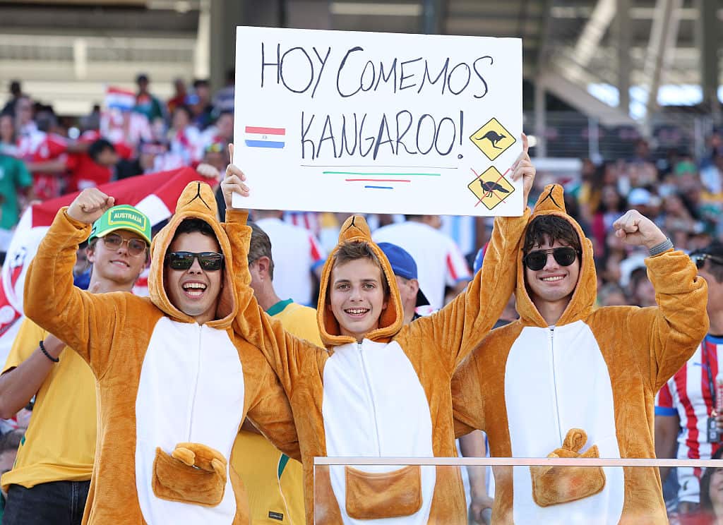 Fans dressed as kangaroos hold up a sign that reads in spanish, today we are eating kangaroo
