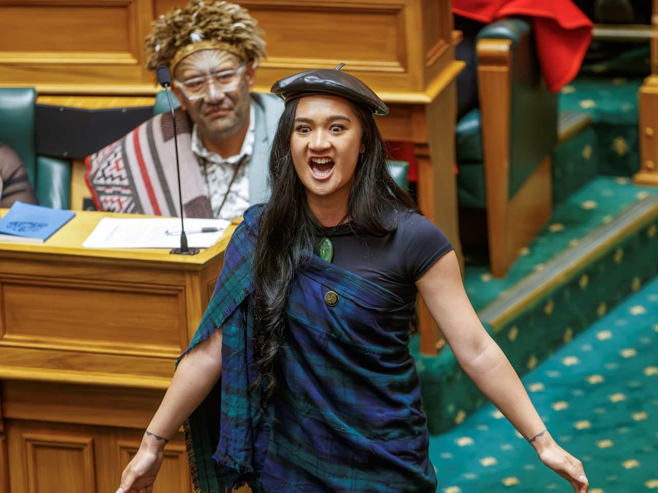 A woman standing and performing a war cry inside