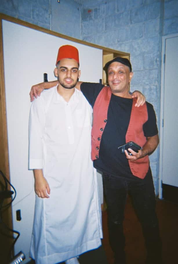 Two men standing arm in arm