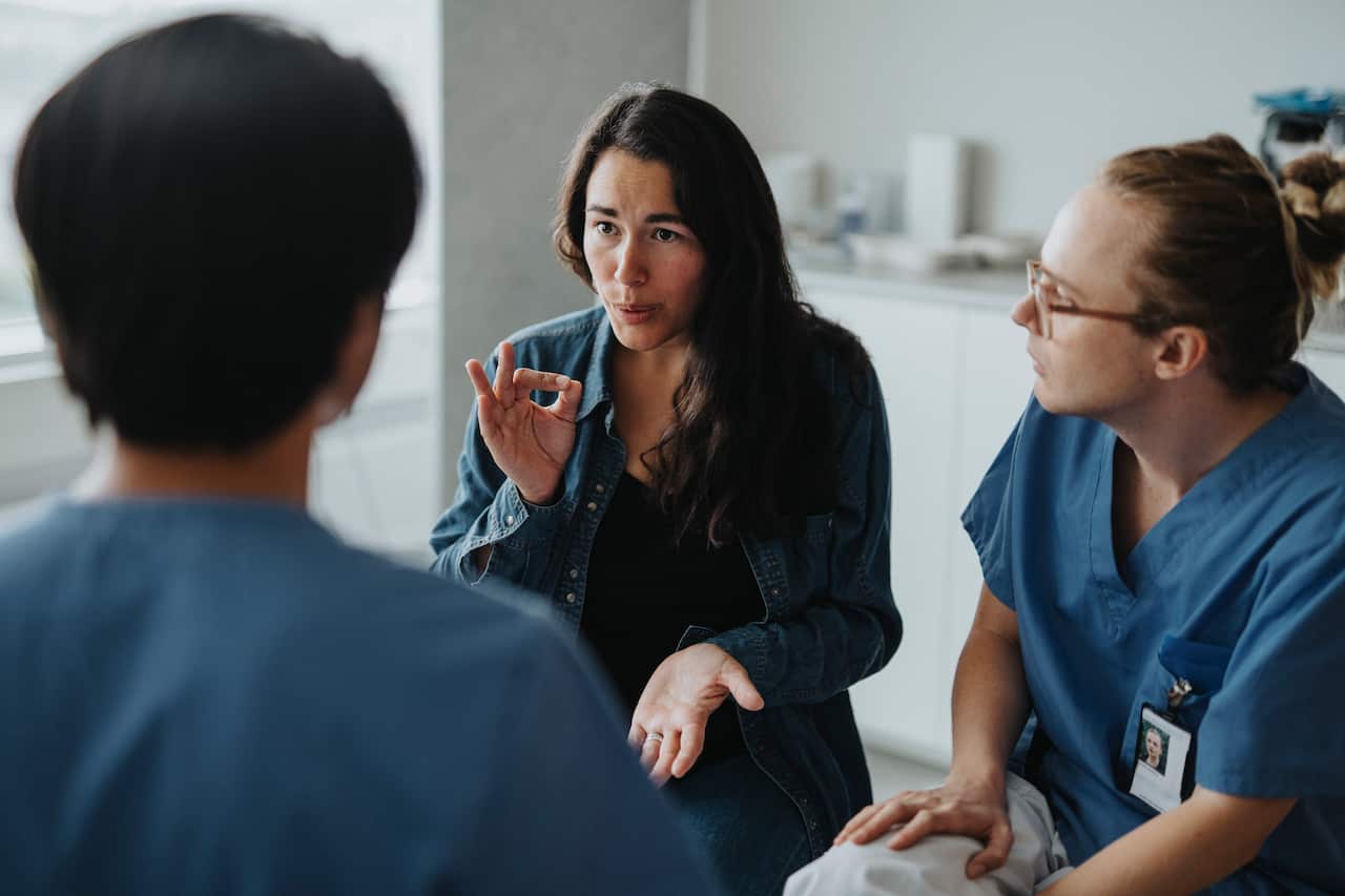 Female patient communicating with medical worker through sign language at hospital: Australia Explained – Translating and interpreting