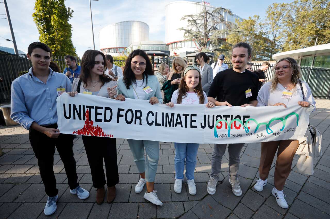 Six teenagers holding up a banner that reads: "United For Climate Justice".