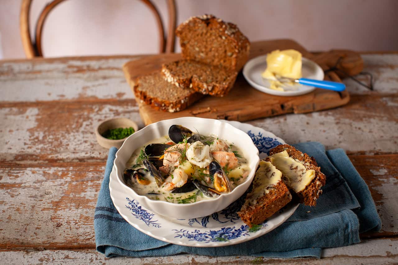 Seafood chowder in a bowl, with buttered brown soda bread. 