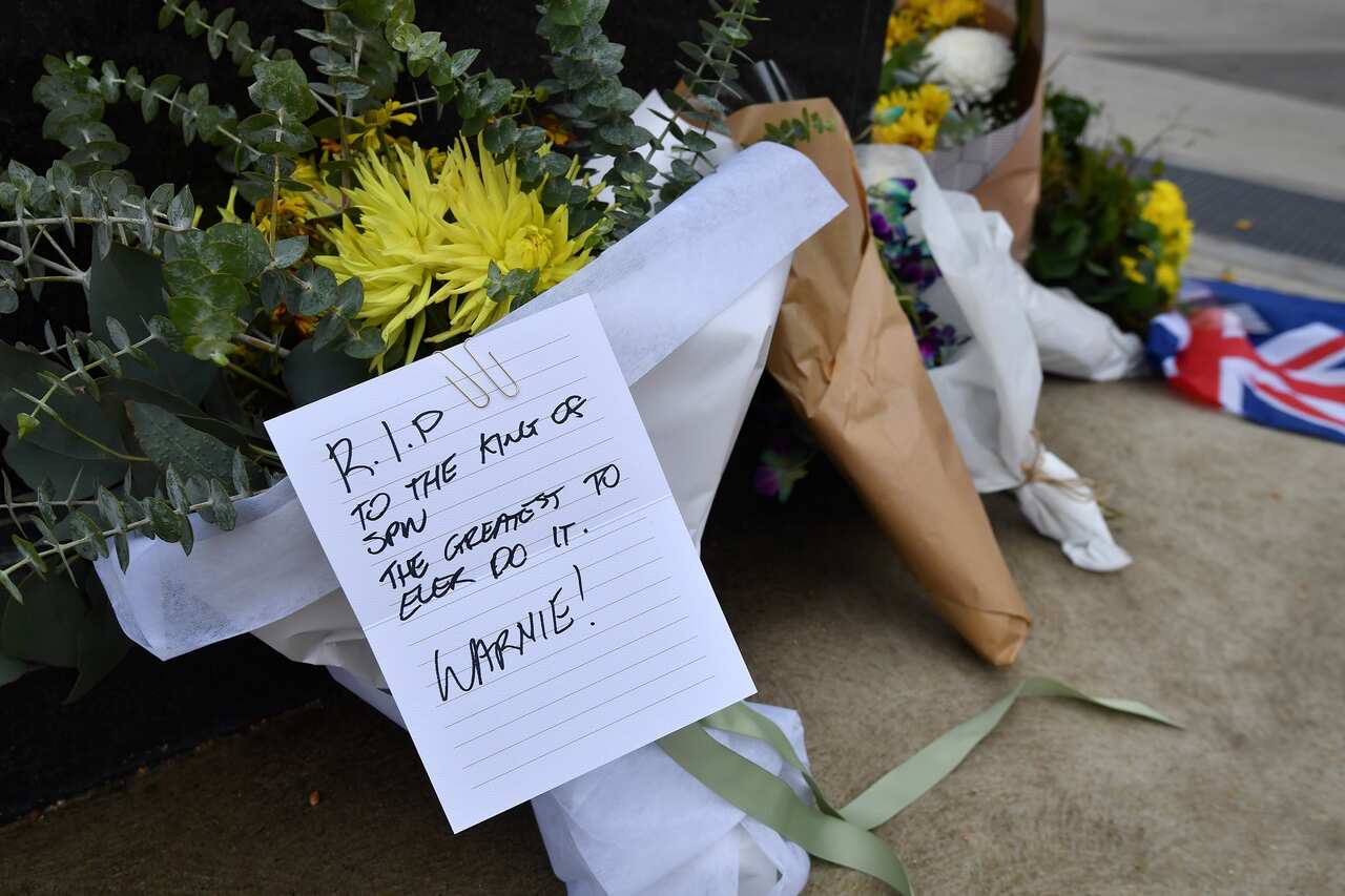 Fans leave floral tributes and messages in memory of Shane Warne outside the MCG in Melbourne, 5 March 2022.  