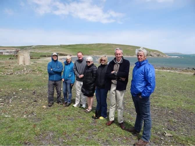 A group of people standing next to the ocean
