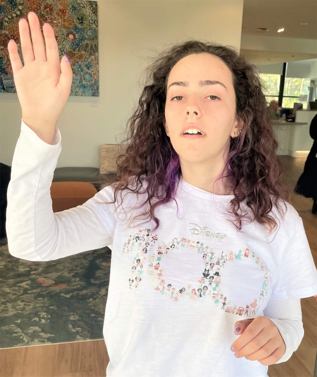 A young woman standing and waving her hand.