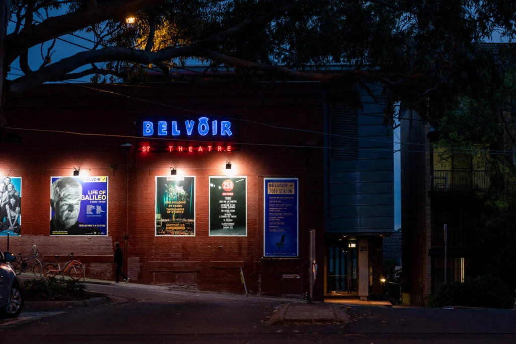 Exterior of Belvoir St Theatre in Surry Hills, New South Wales with neon lights and theatre posters at night.