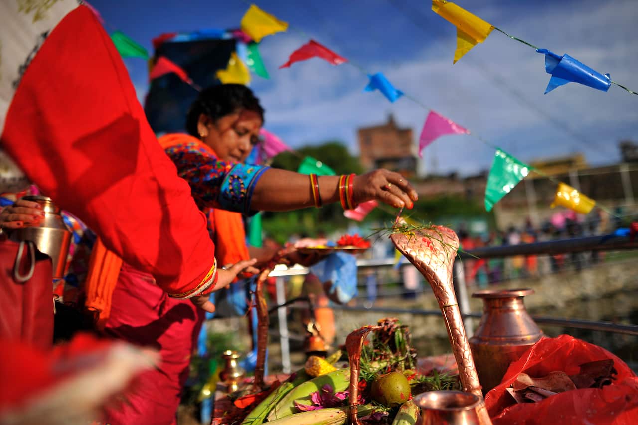 Devotees offering ritual prayer during Nag Panchami at Taudaha Lake in Kirtipur, Kathmandu, Nepal.