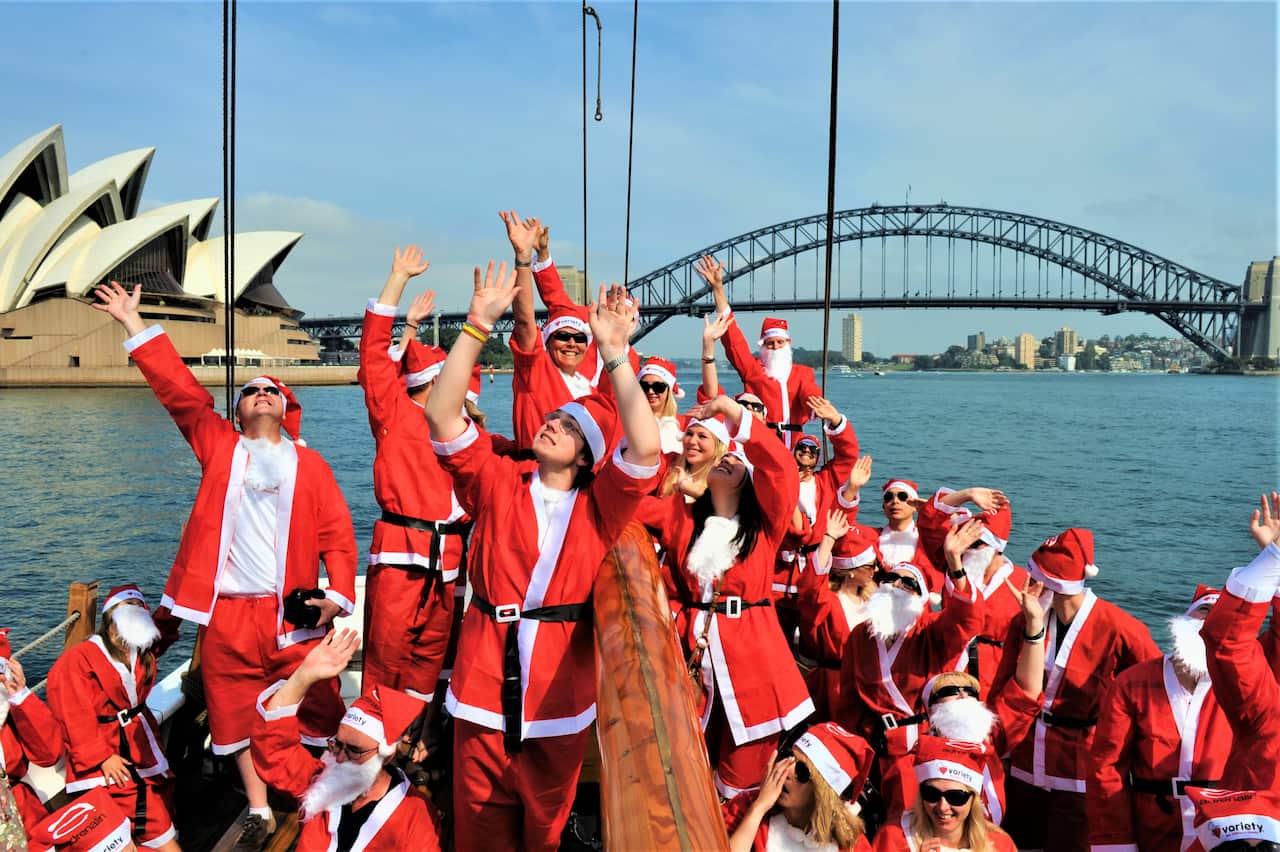 Ninety people dressed as Santa Claus took to Sydney Harbour, sailing under the Harbour Bridge and past the Opera House