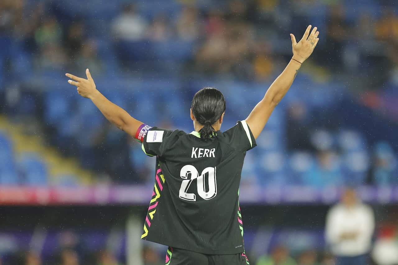 A woman pictured from behind with her arms raised with the name Kerr on the back of her jersey
