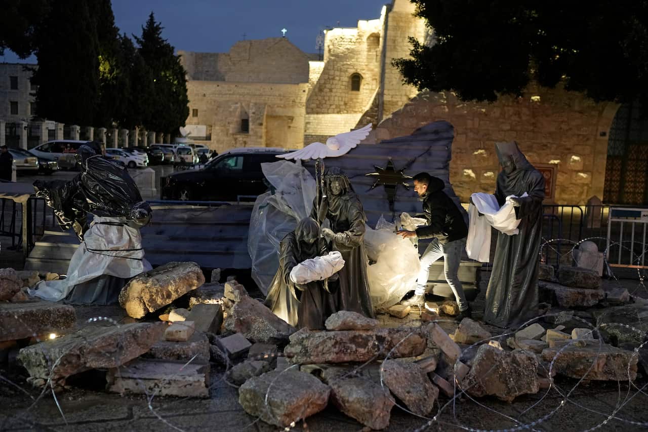 A nativity scene amid rubble at night