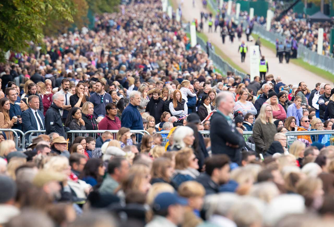 People watch the funeral of Queen Elizabeth II on a big screen, on the Long Walk at Windsor Castle, London.