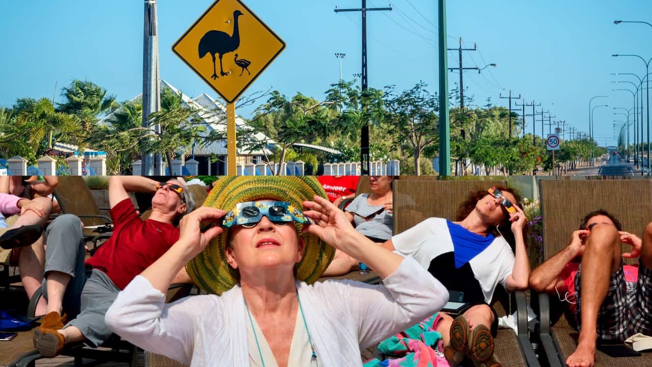 People wearing special eclipse glasses, looking to the sky, below an image of an empty road with a yellow sign with emus on it.