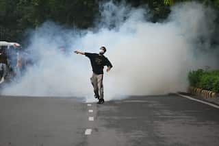A person wearing a mask is seen amid smoke