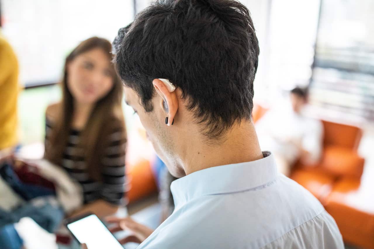 Hearing impaired man with assistive technology