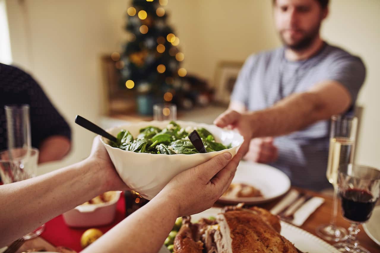 Cropped shot of a unrecognisable woman serving a bowl of healthy greens at Christmas lunch