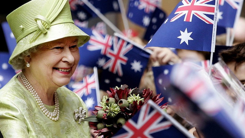 Queen Elizabeth II receives flowers from waiting school children after the Commonwealth Day Service in Sydney on March 13, 2006..jfif