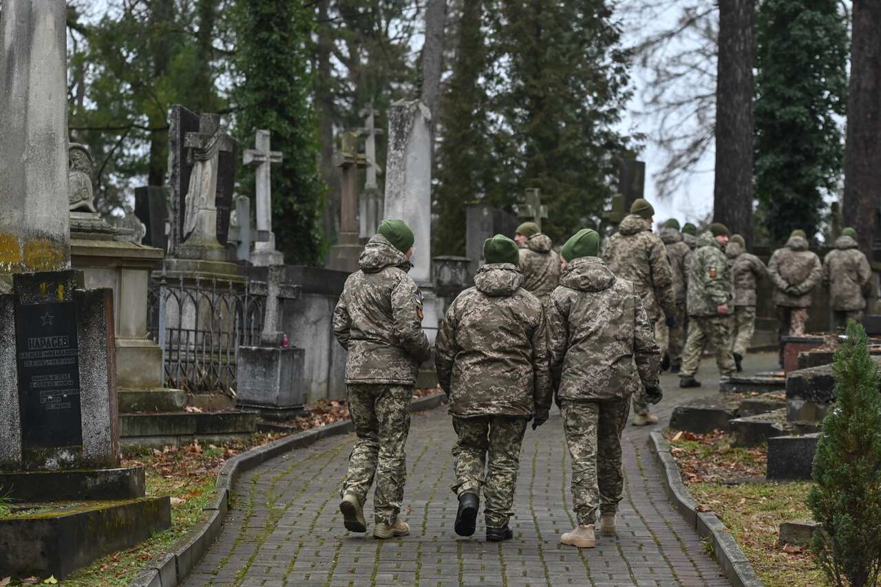 Soldiers walk in a cemetery.